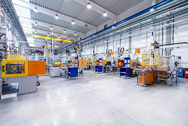 Horizontal image of huge new modern factory with robots and machines producing industrial plastic pieces and equipment. Wide angle view of futuristic machines standing on flooring and having the monopole of all work, taking the place of human work. There is not necessary use human hand. Wide angle, view, no people, space for copy.